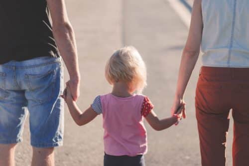 Padre y Madre paseando con su hija de la mano